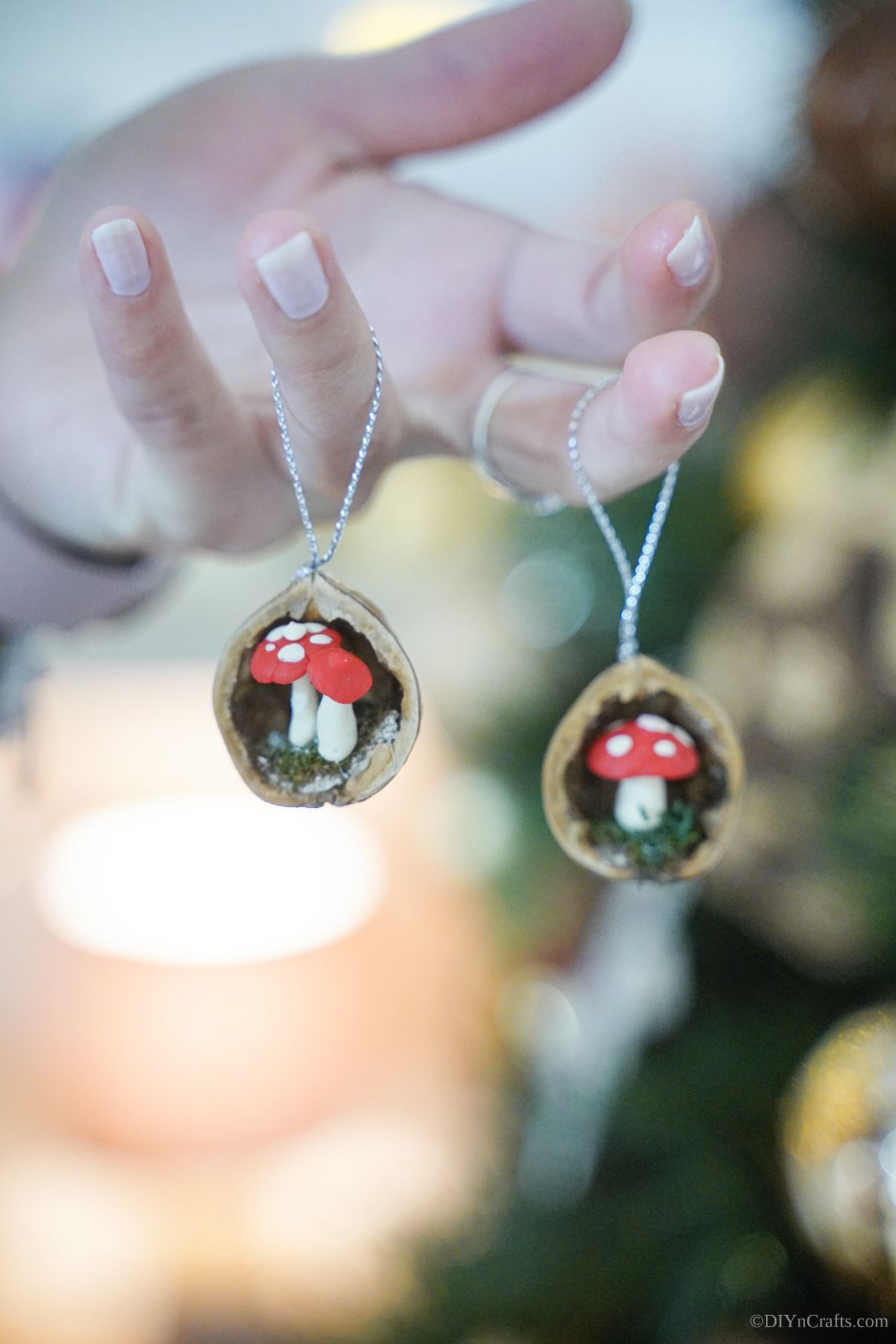 walnut shell ornaments dangling off fingers