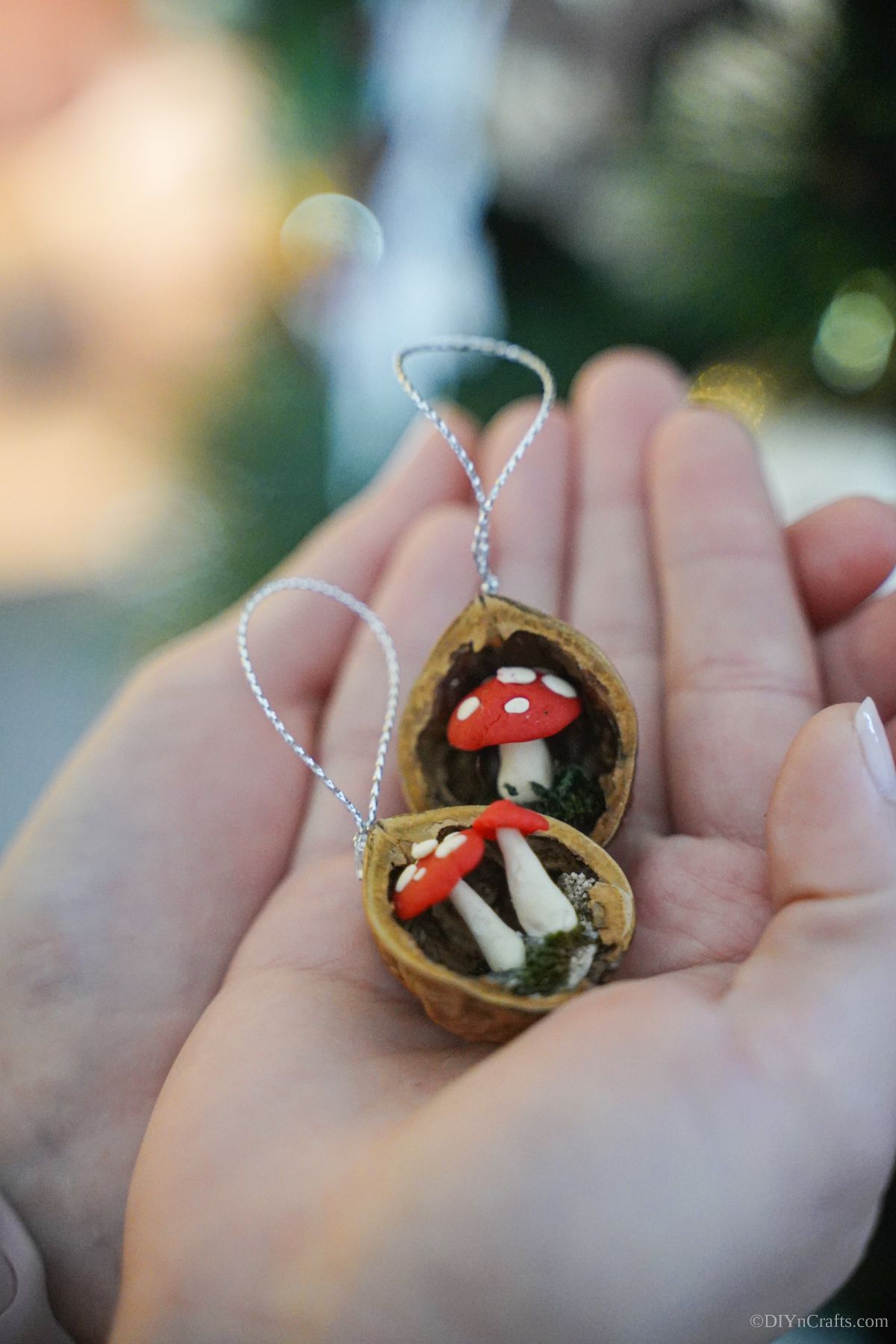 hands together holding two miniature mushroom ornaments