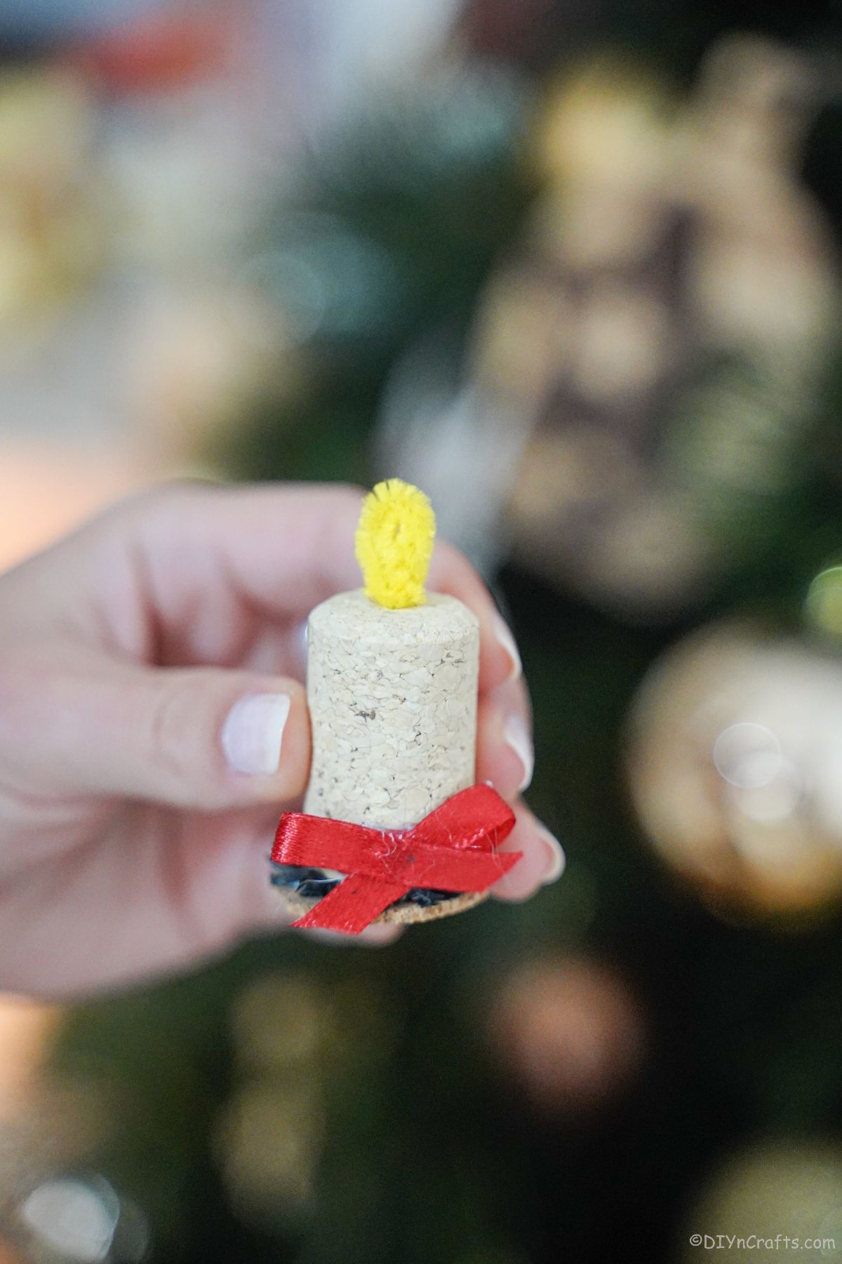 mini candle made from wine cork in front of Christmas tree