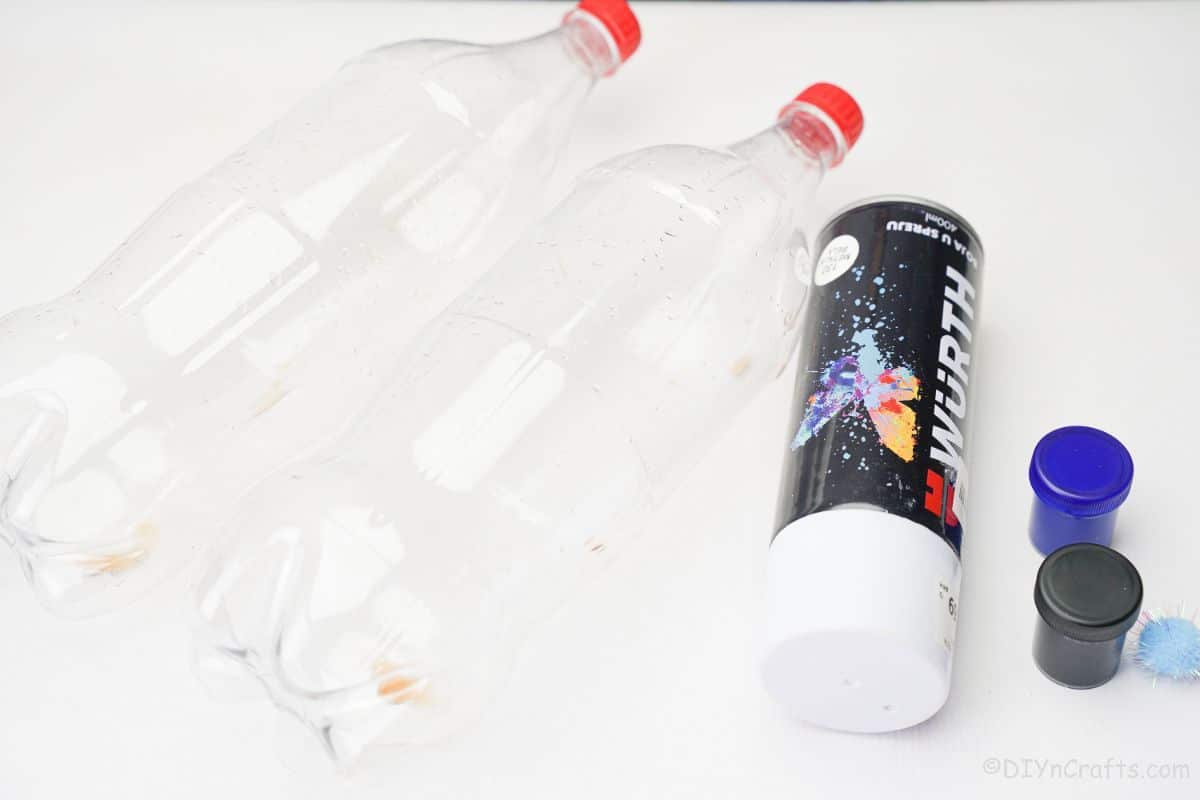 bouteilles de soda en plastique peinture en aérosol blanche et peinture artisanale sur table blanche