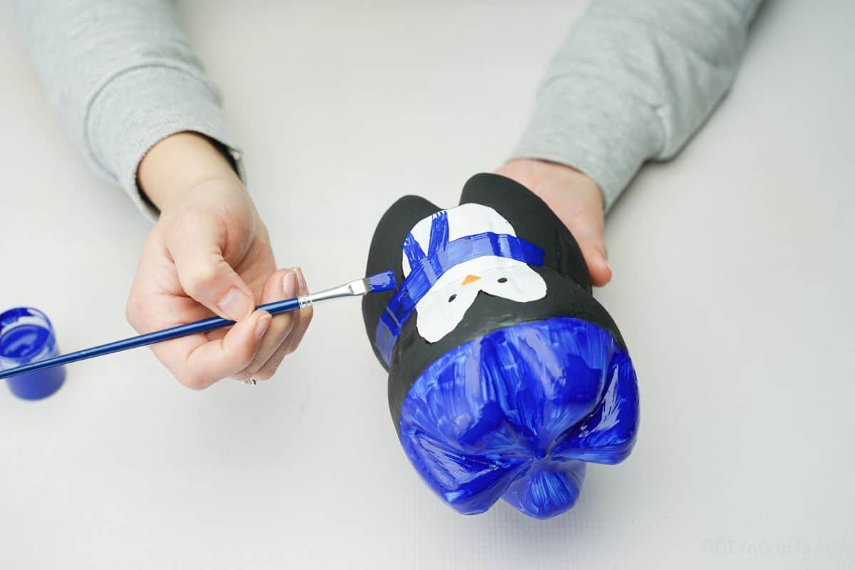 écharpe bleue peinte à la main sur un pingouin bouteille recyclé
