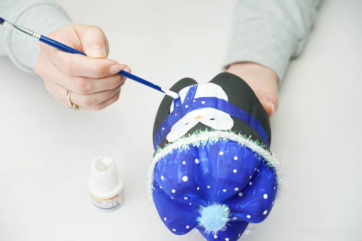 hand painting white dots on blue penguin scarf