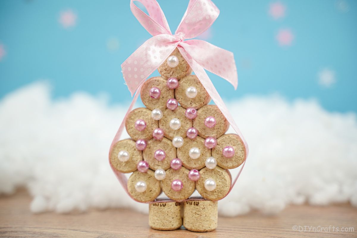 cork tree with pink ribbon and white faux snow beads with blue background