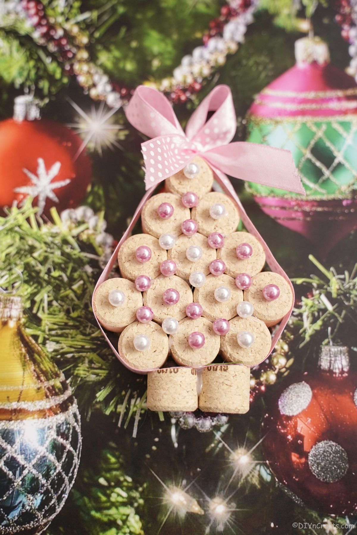 miniature cork tree with pink beads on holiday paper