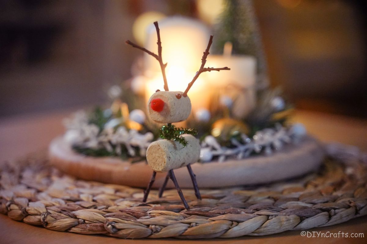 cork reindeer on jute placemat with candle in background