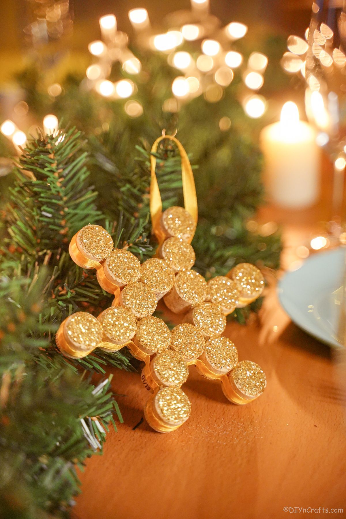 gold snowflake leaning against greenery on table