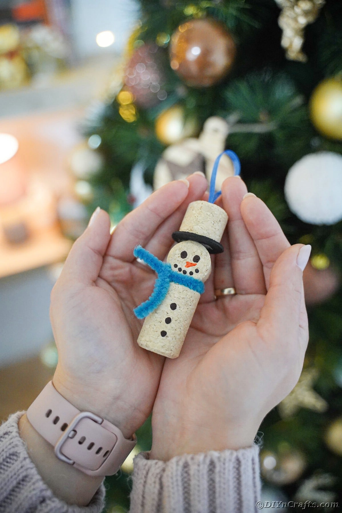 hands holding a wine cork snowman ornament