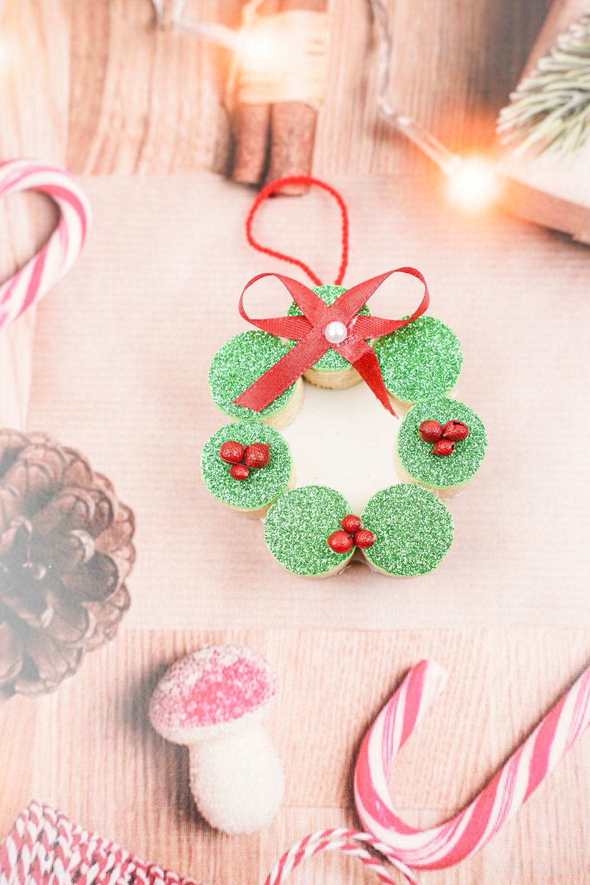 pinecone and peppermint paper underneath green cork wreath ornament