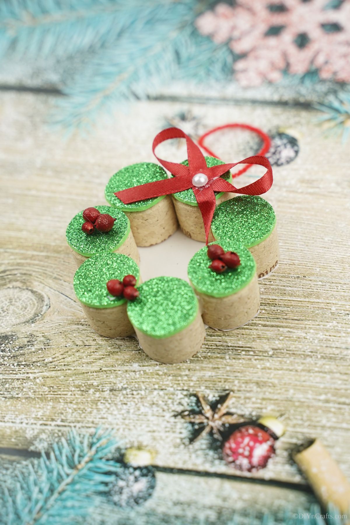 miniature cork wreath with green top on table with blue background