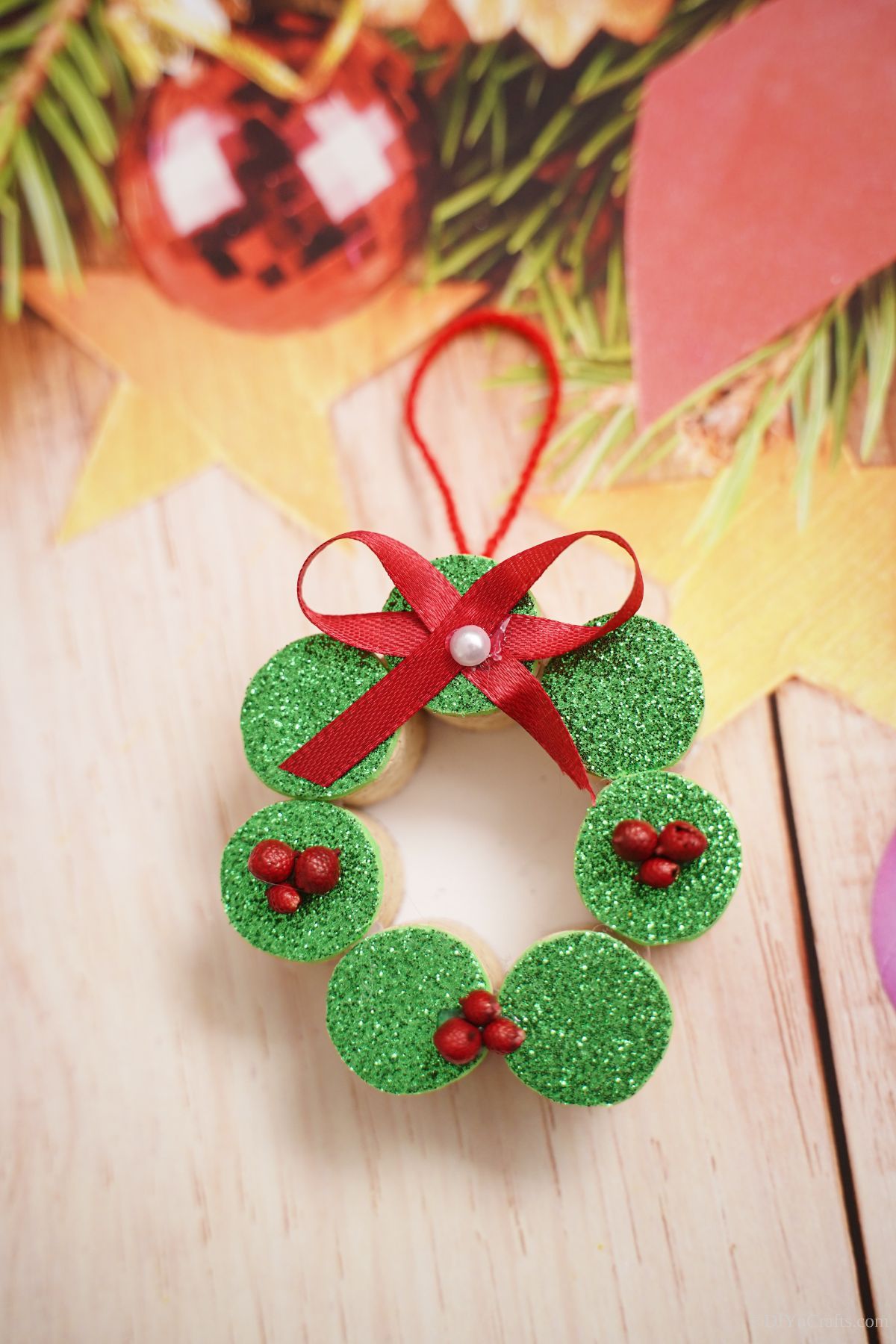 wine cork wreath ornament laying on holiday themed paper