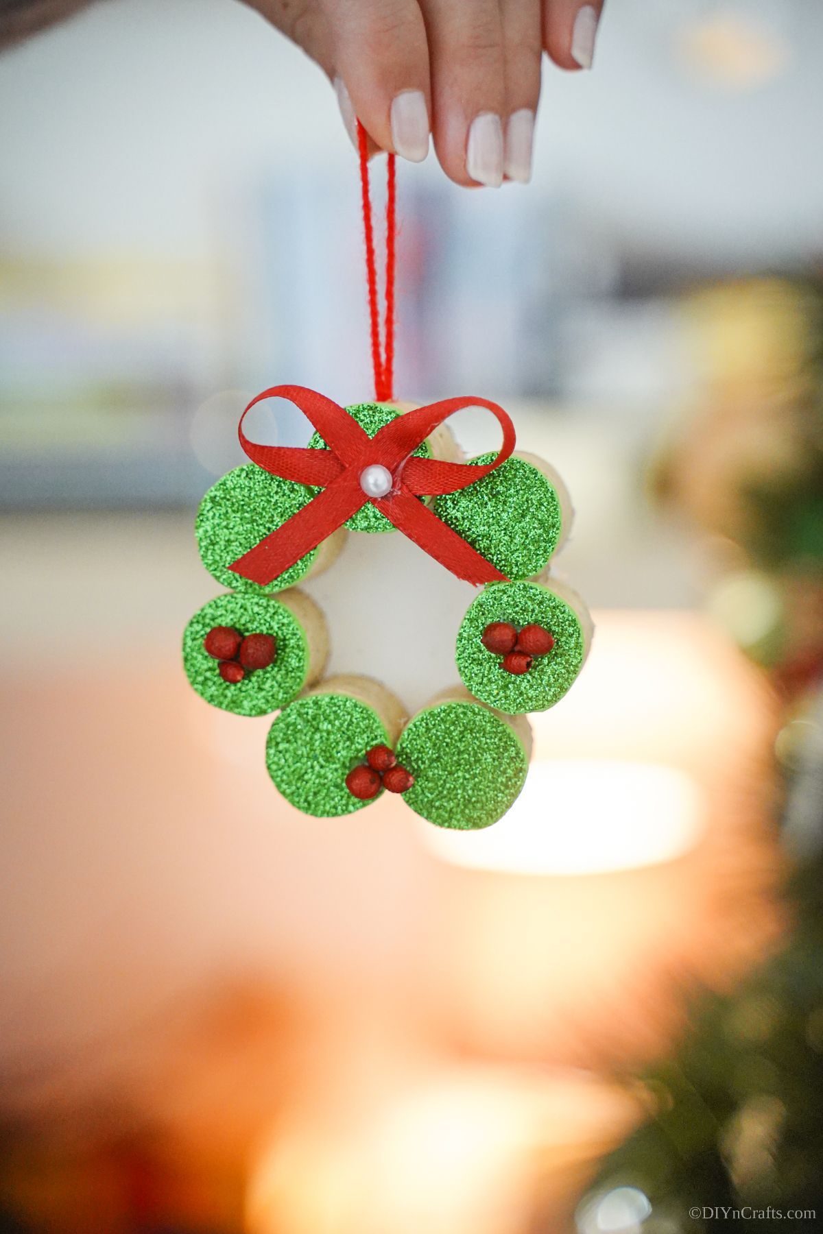 hand holding green cork wreath ornament