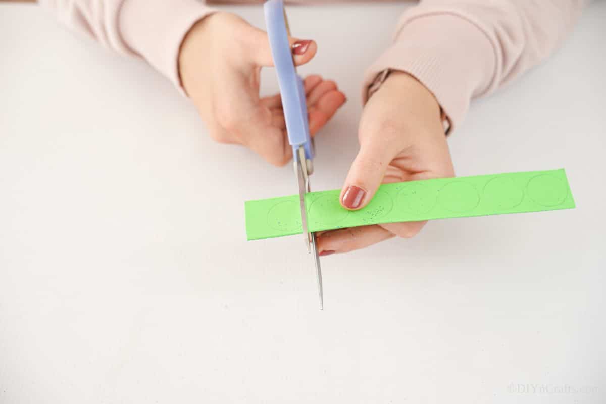blue scissors cutting green foam paper