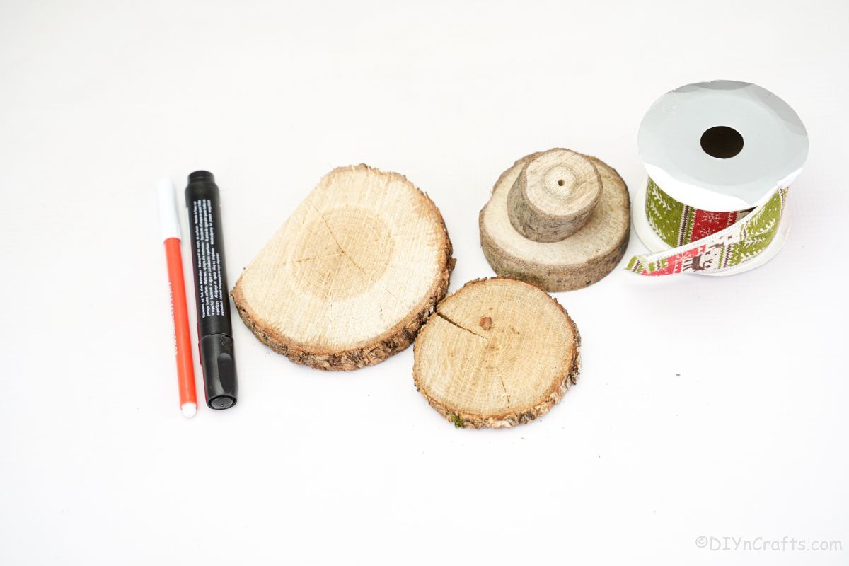 wood slices ribbon and markers on white table