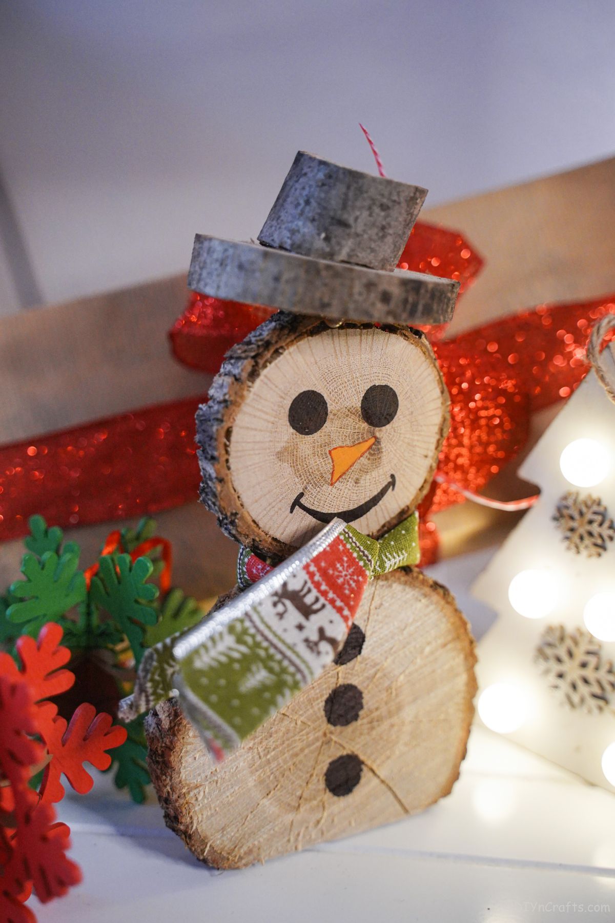 wooden snowman against red box with white tree