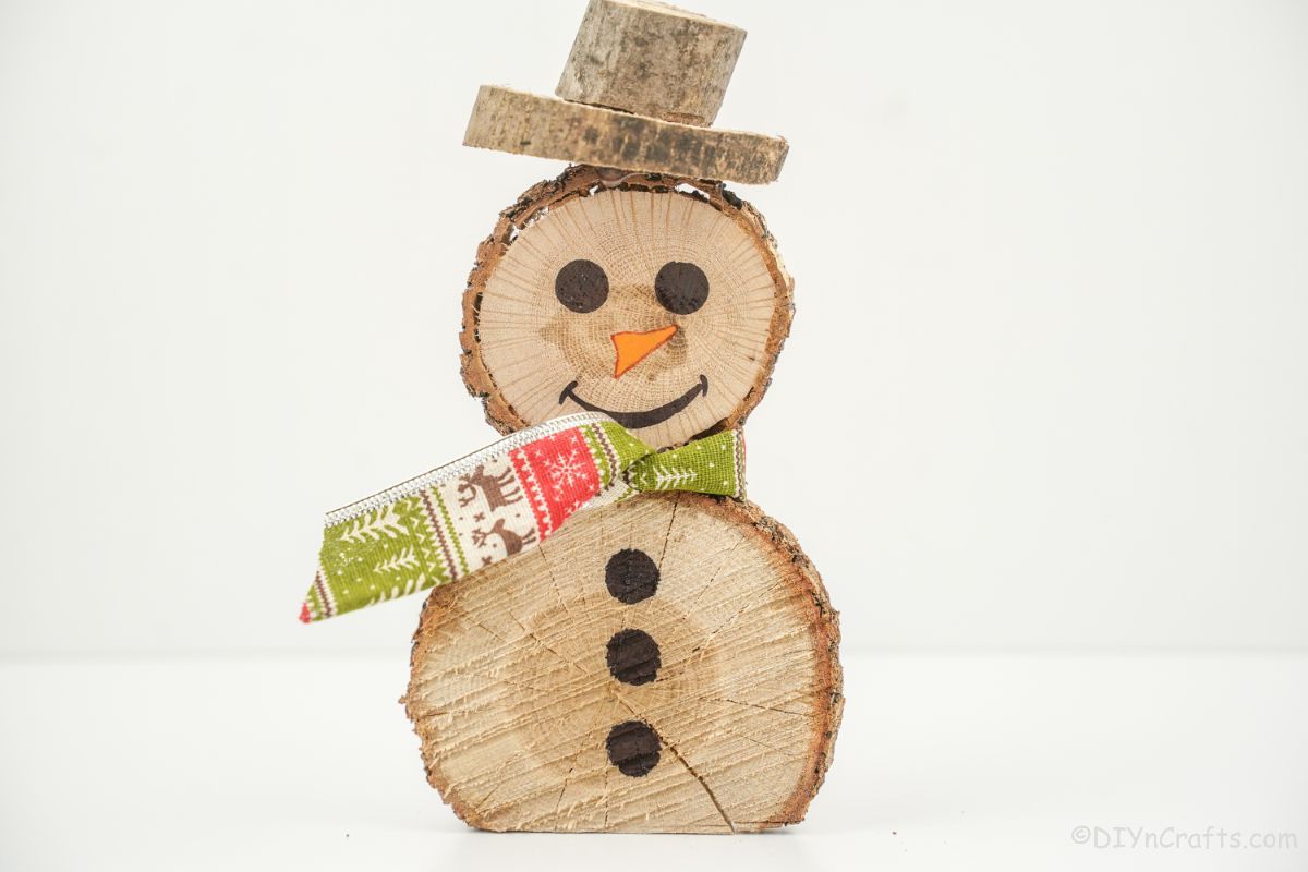 holiday wooden snowman sitting at white table