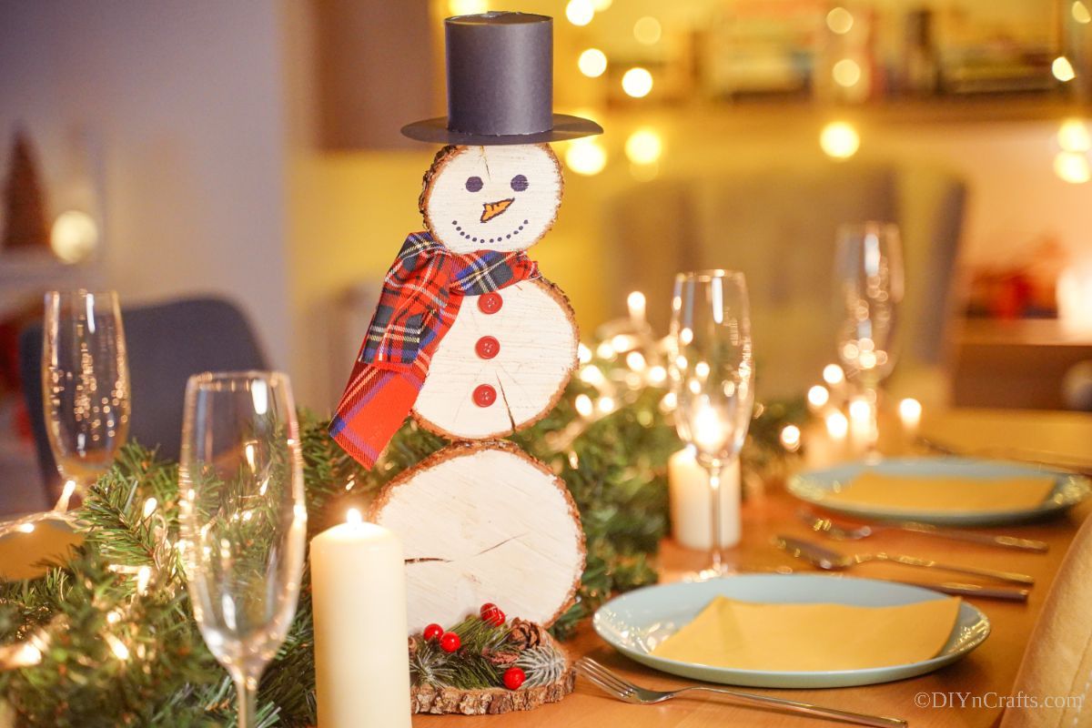 wood slice snowman on table with place settings