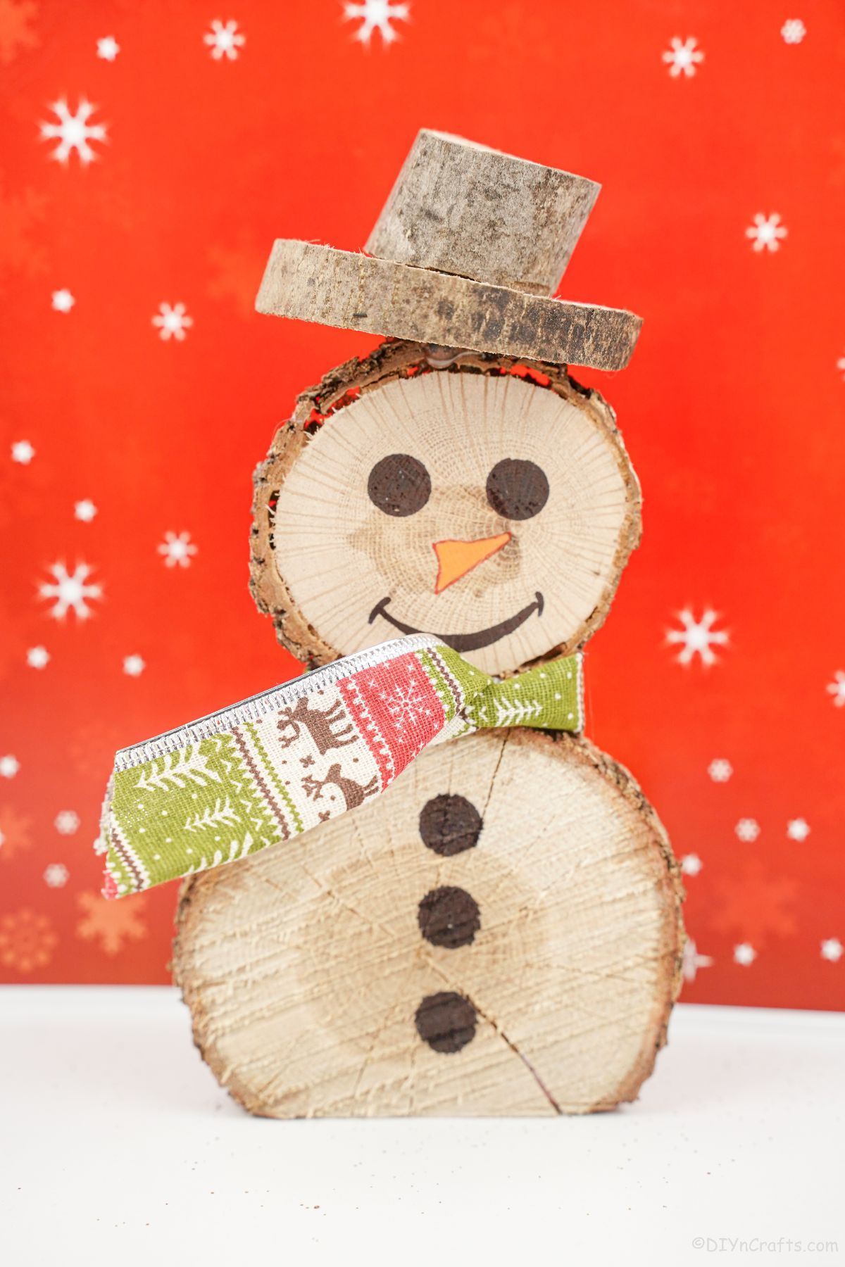 wood slice snowman on white table with red background