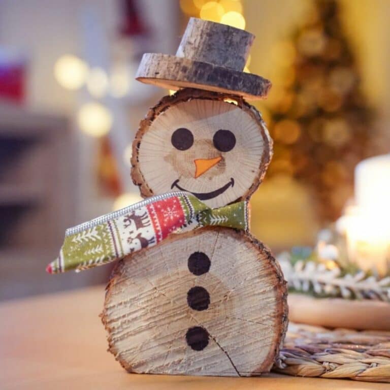 wood slice snowman on wood table with green holiday scarf