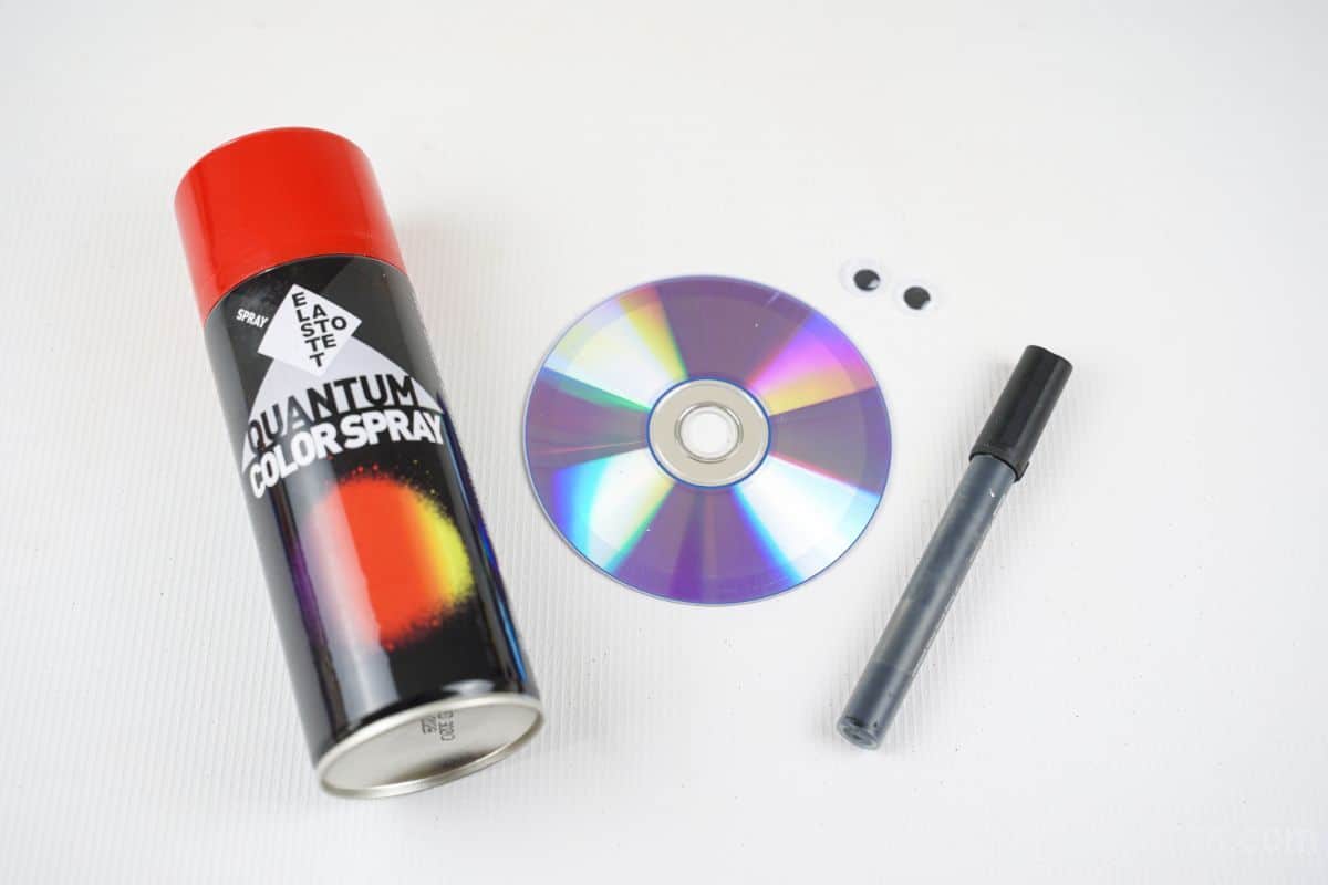 spray paint can and cd on table by black marker