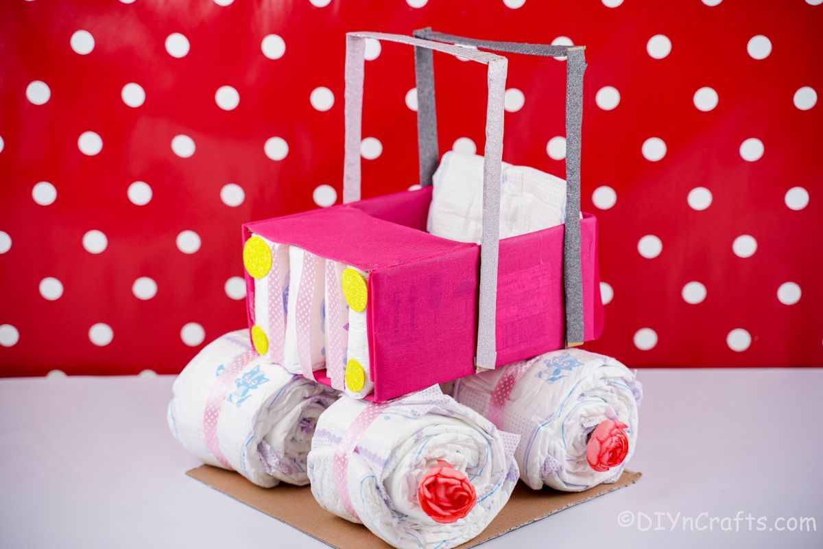 red and white polka dot background with safari car diaper cake in front