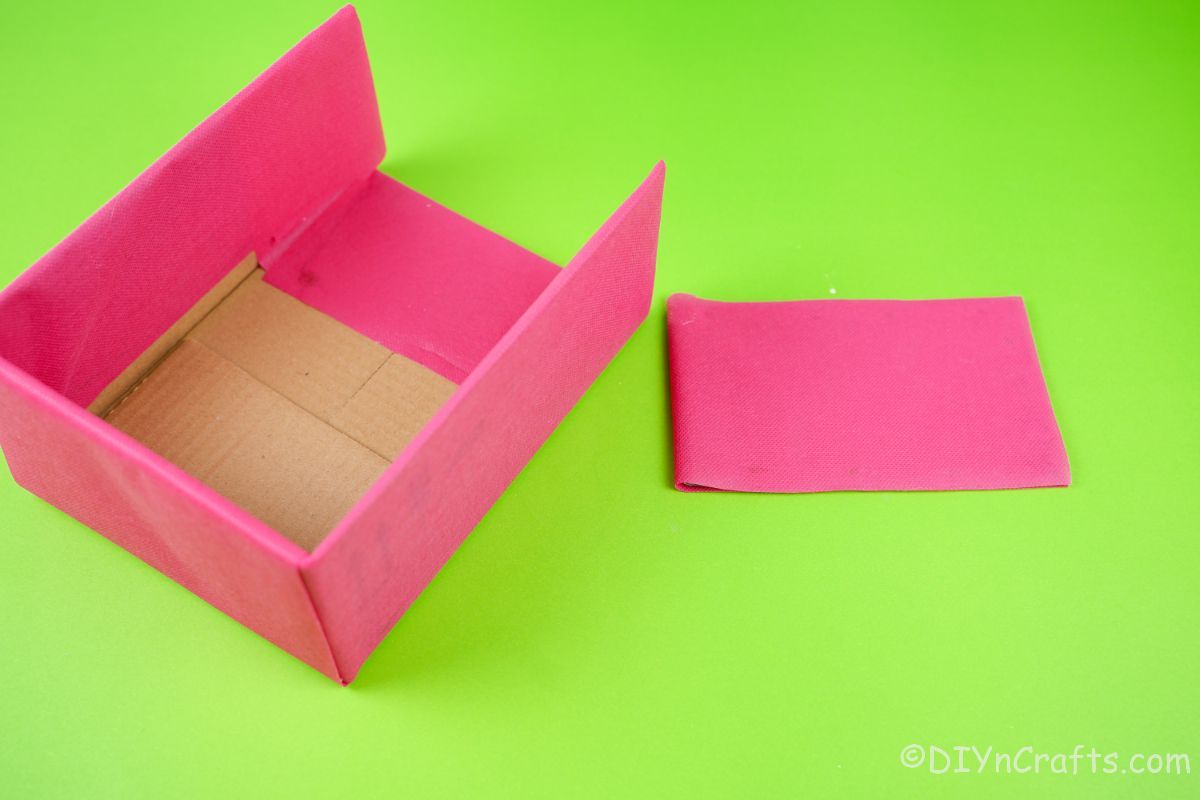 gluing pink paper over cardboard pieces