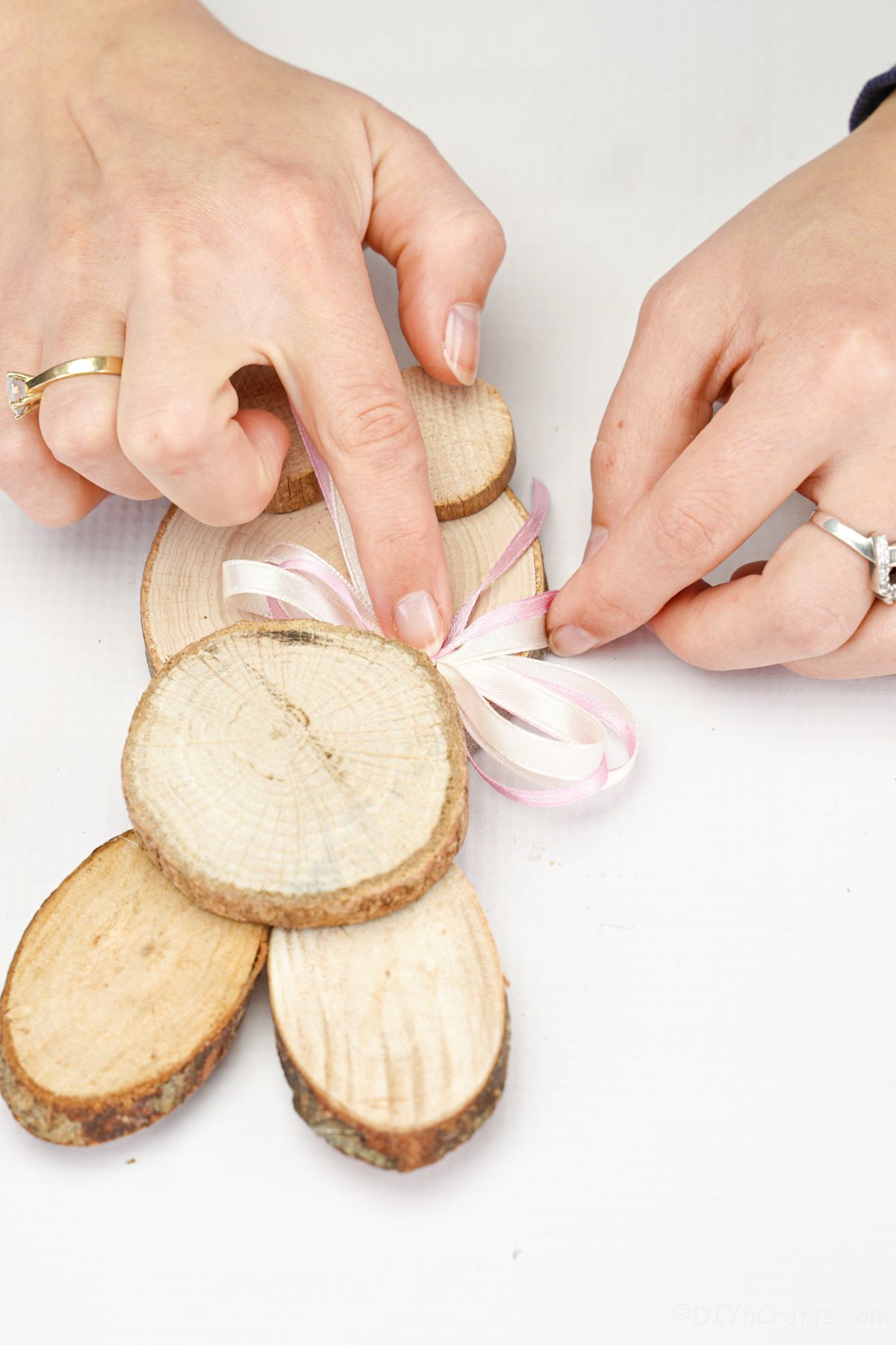 hand gluing ribbon onto wood slice bunny