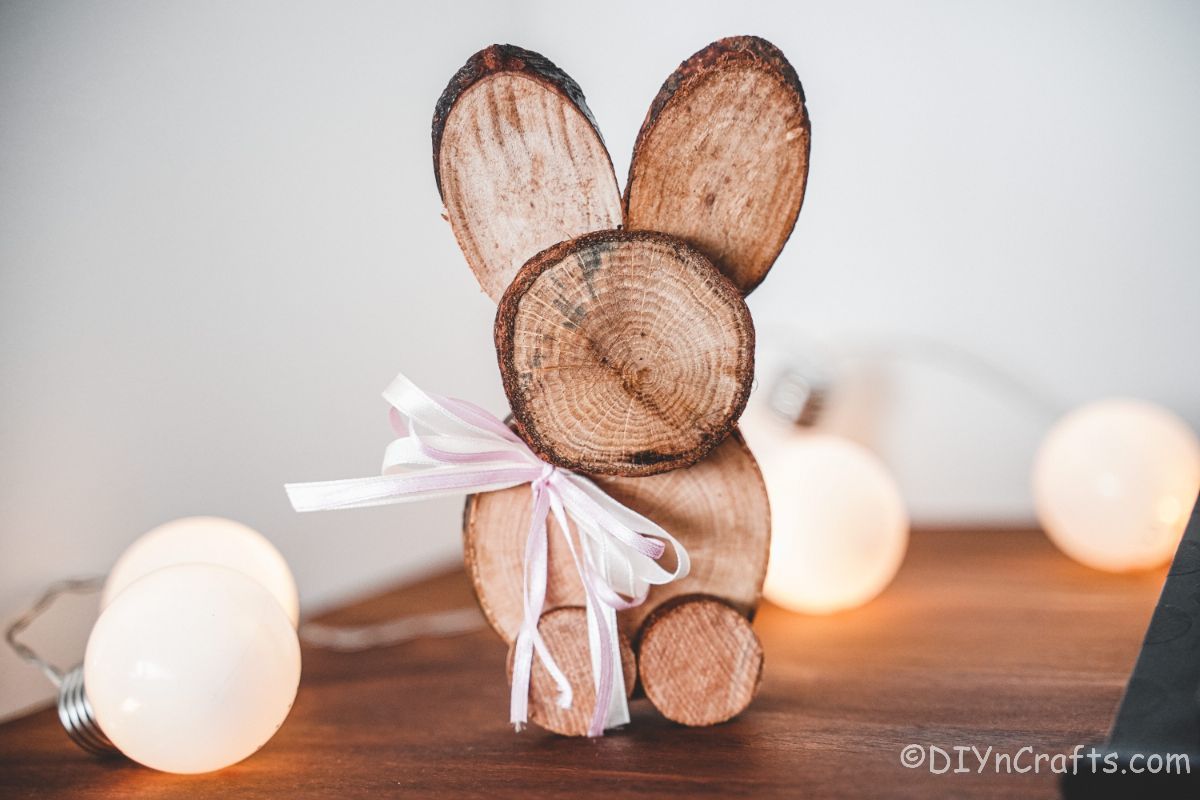bunny decoration with pink ribbon on table with lights in background