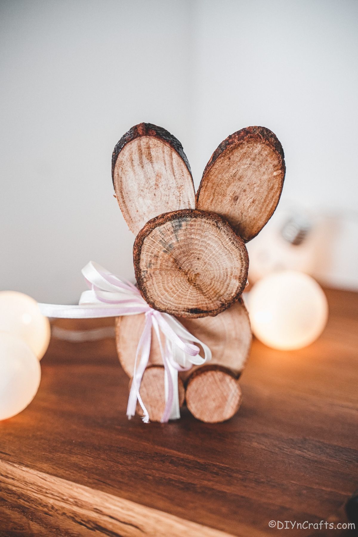 wood slice bunny on table with white lights in background