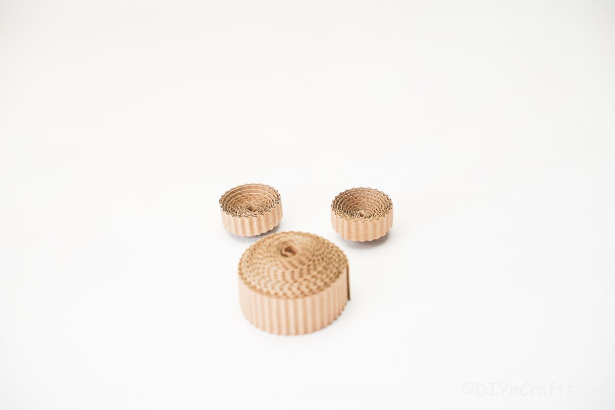 three rolled cardboard circles on table