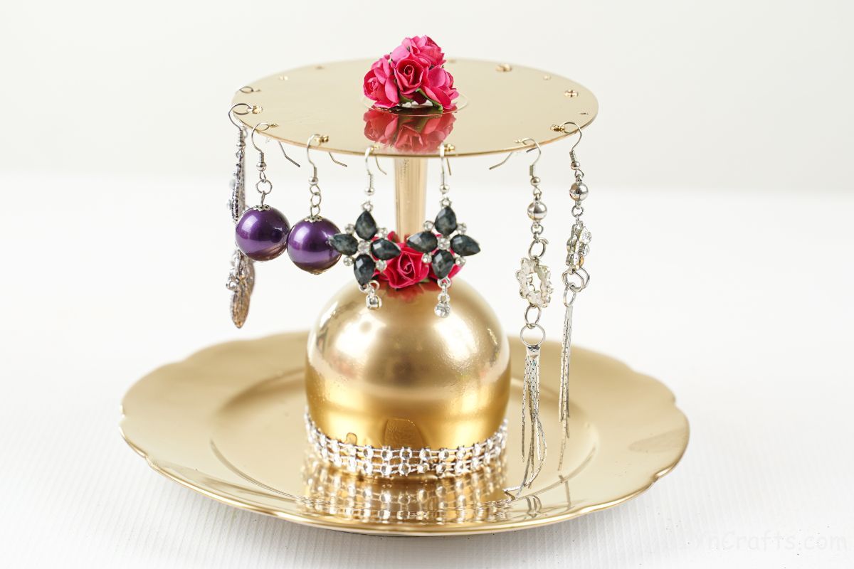 gold painted plate and cd jewelry holder on white table