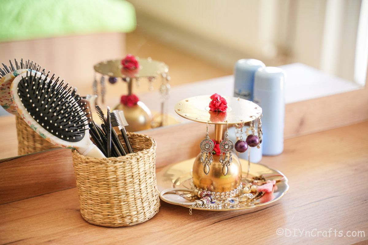 small basket of hair tools beside gold jewelry stand
