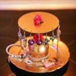gold jewelry stand on black table with jewelry on top of stand