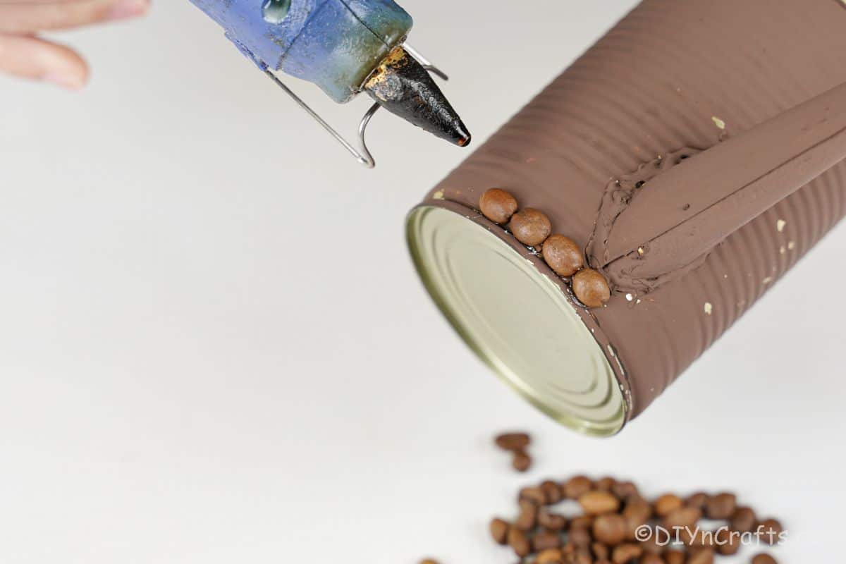 hot glue gun above brown can with coffee beans