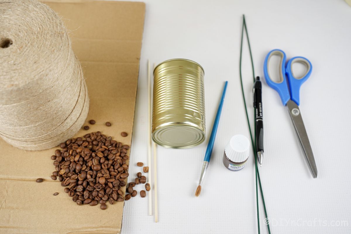 white table holding cardboard tin can coffee beans twine and scissors