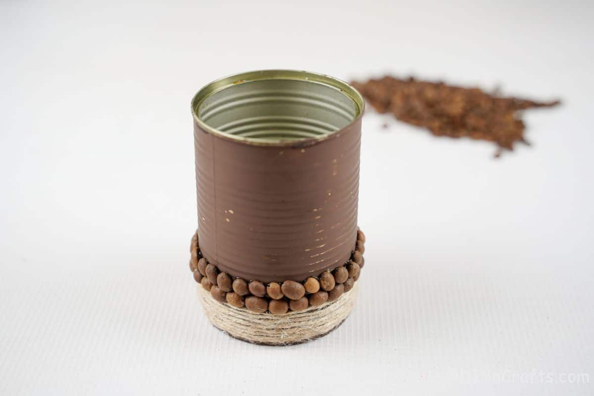 brown tin can with coffee beans and twine on white table