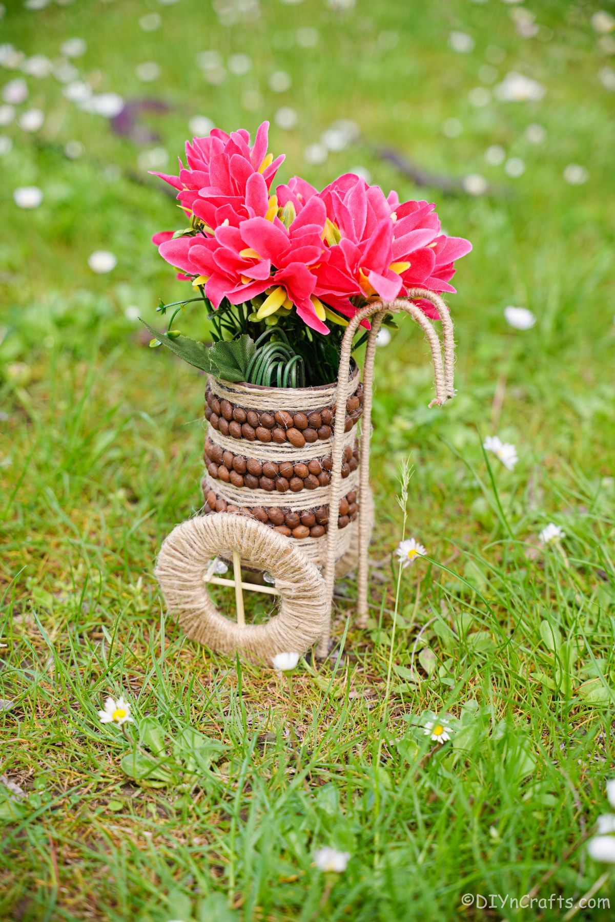 twine wrapped tin can vase with pink flowers on grass