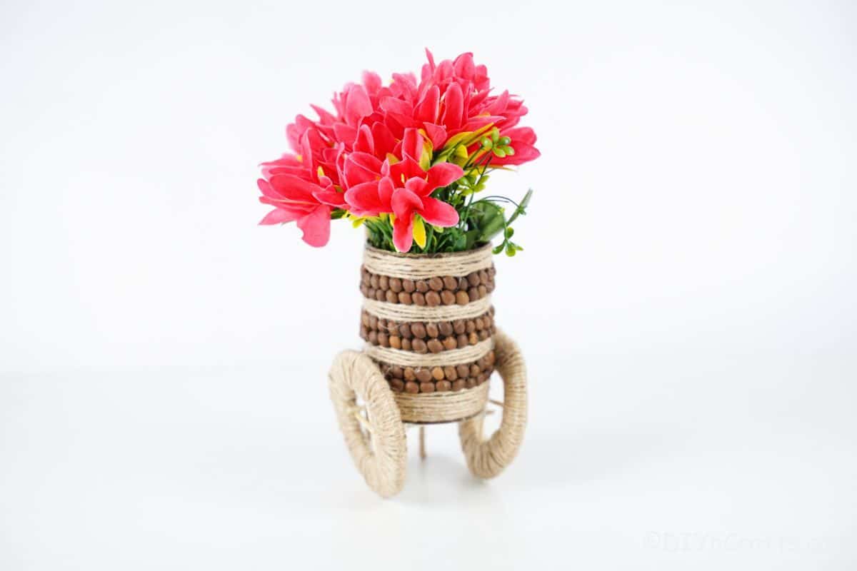 rustic vase with pink flowers on white table