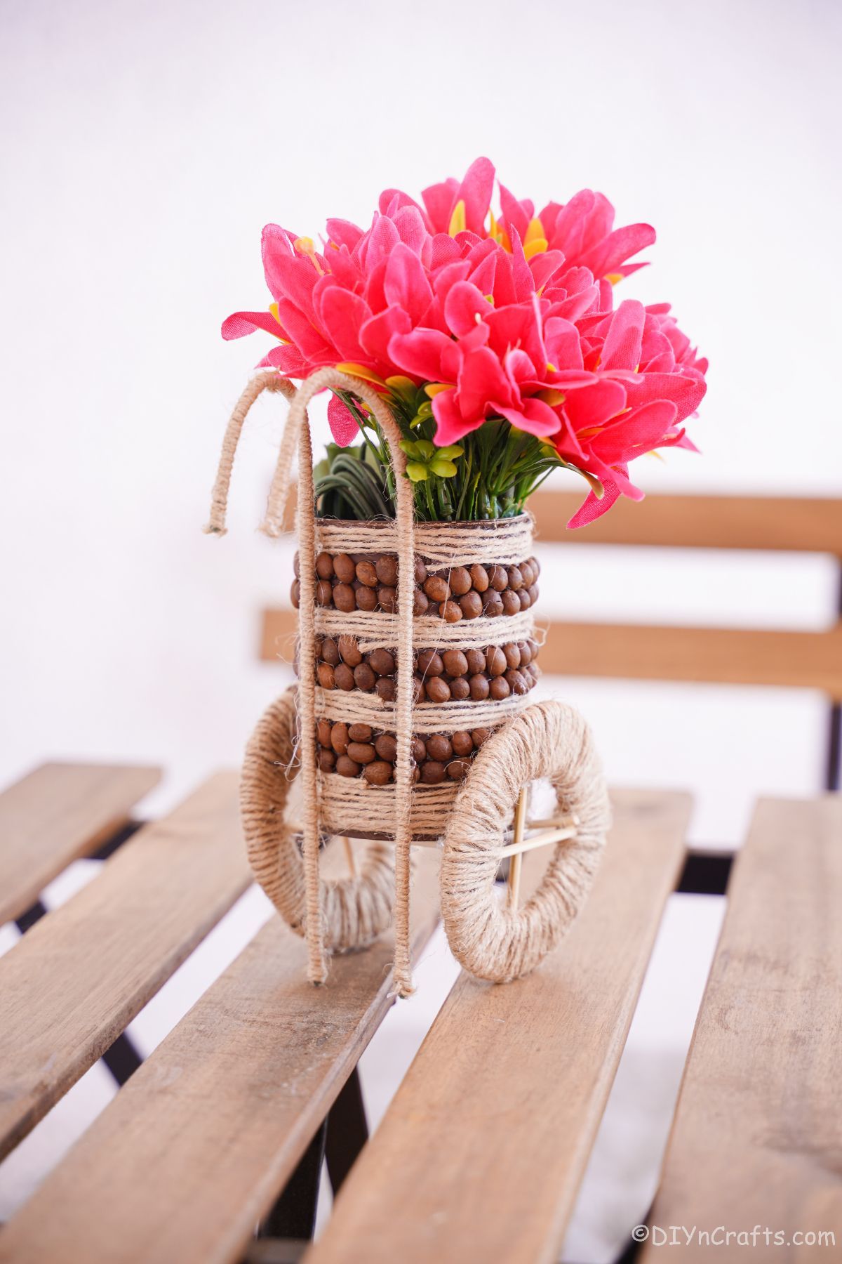 rustic vase of pink flowers on wooden picnic table