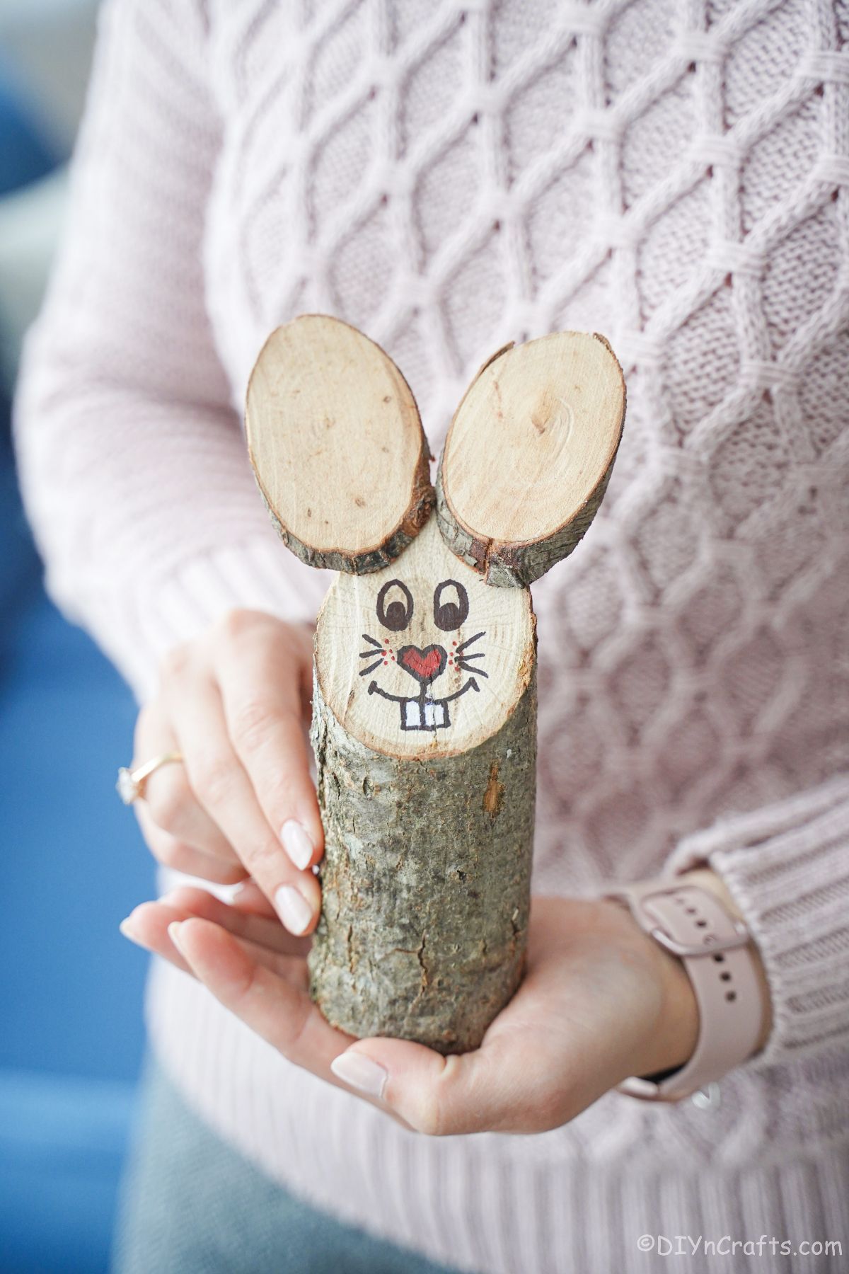 woman holding bunny made of log and wood slices