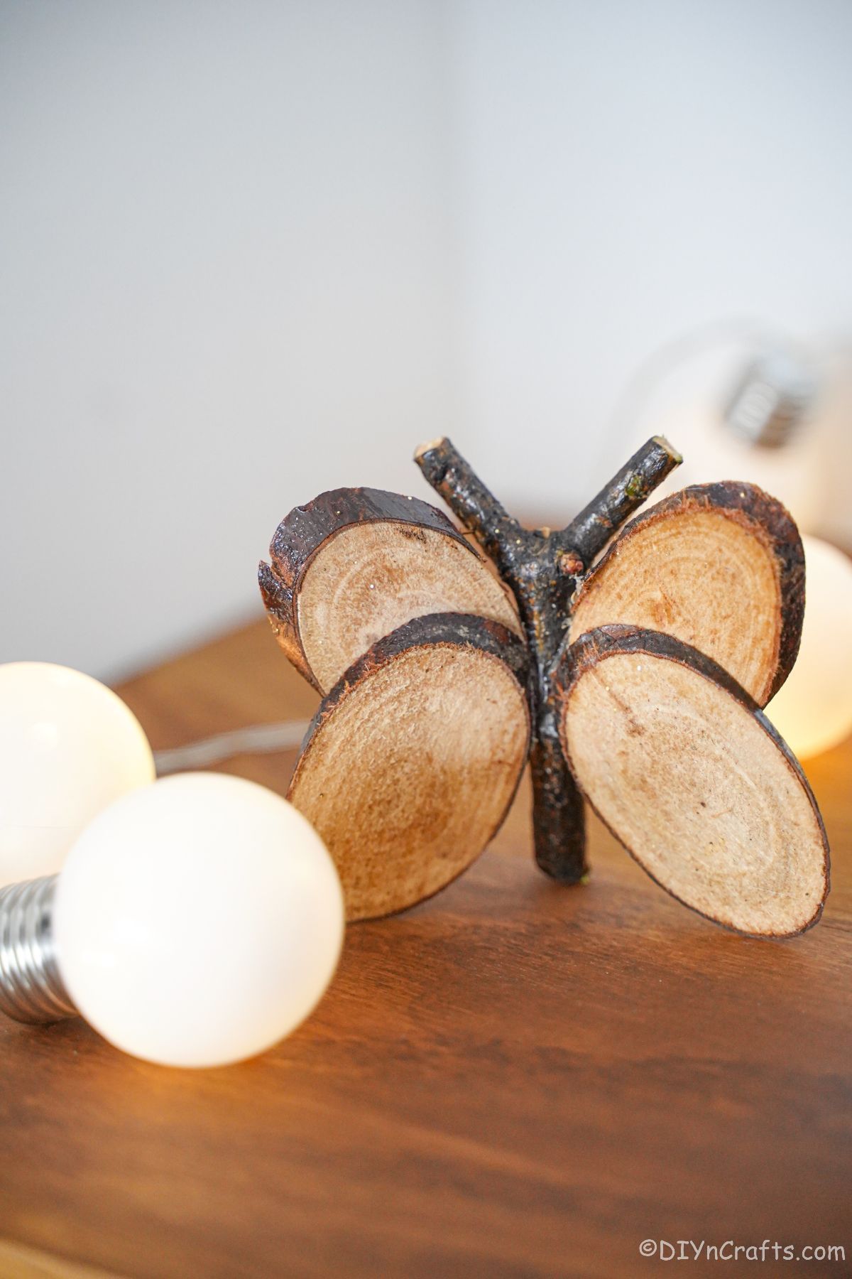 Lumières blanches sur table par papillon en tranches de bois