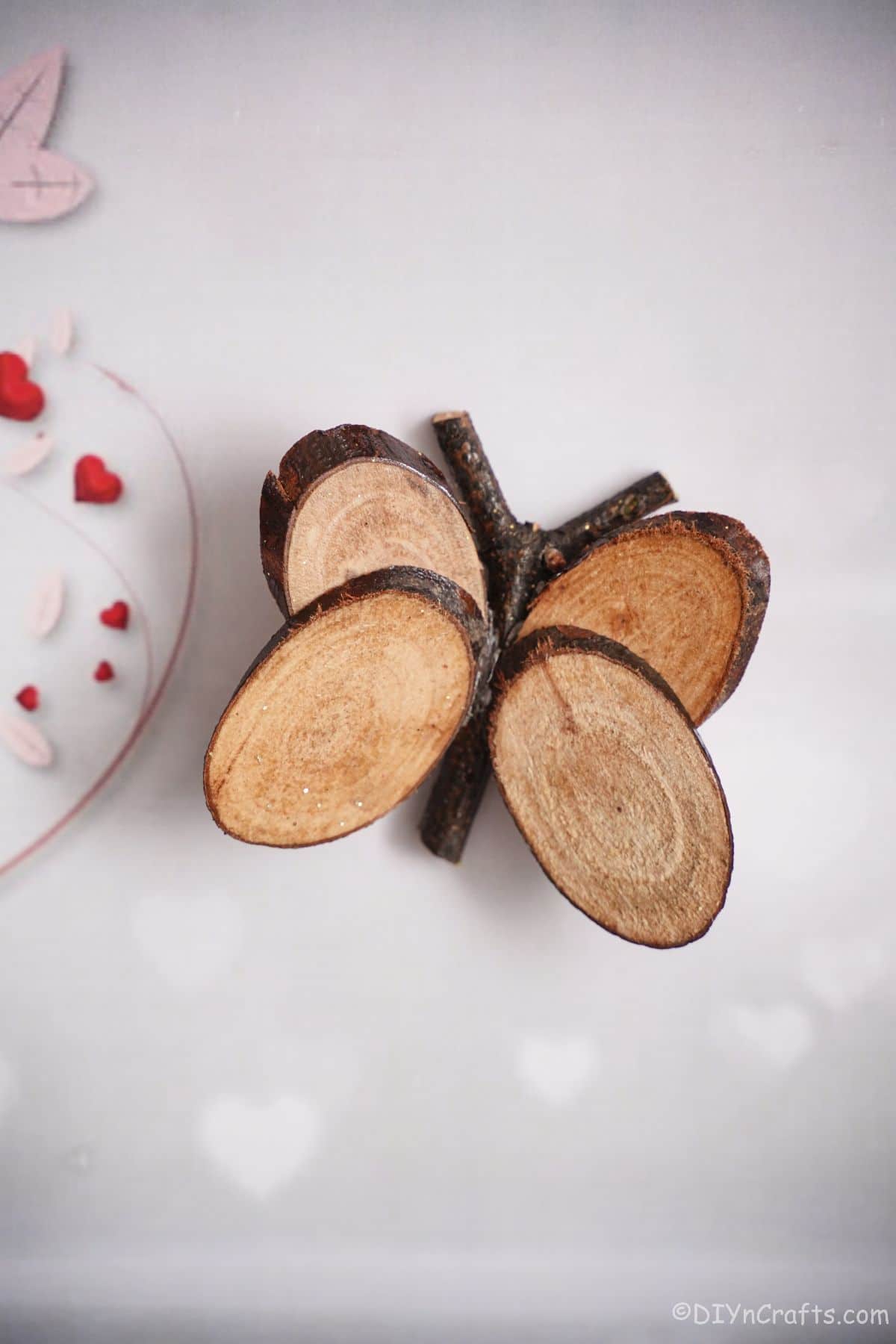 wood slice butterfly on table by red and white plate