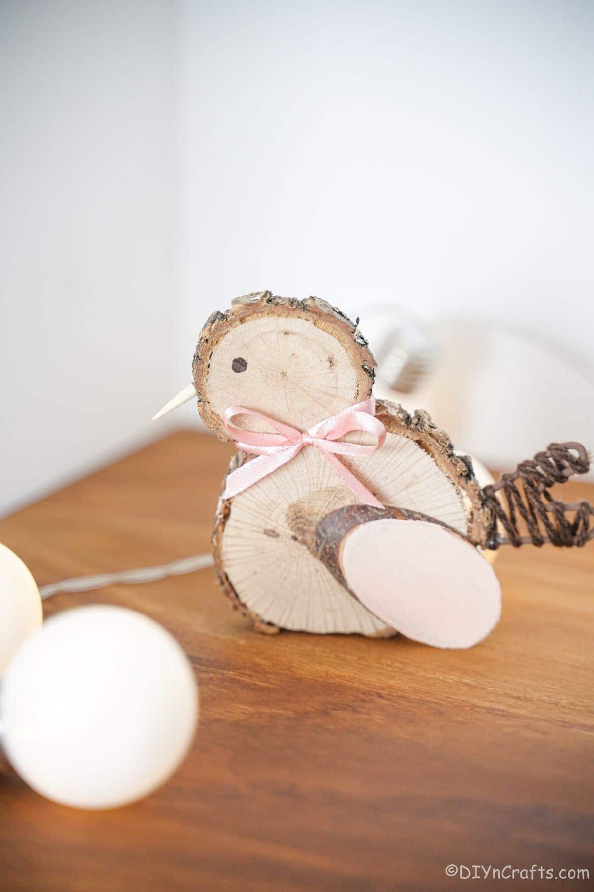 wood slice chicken with pink bow on table with lights