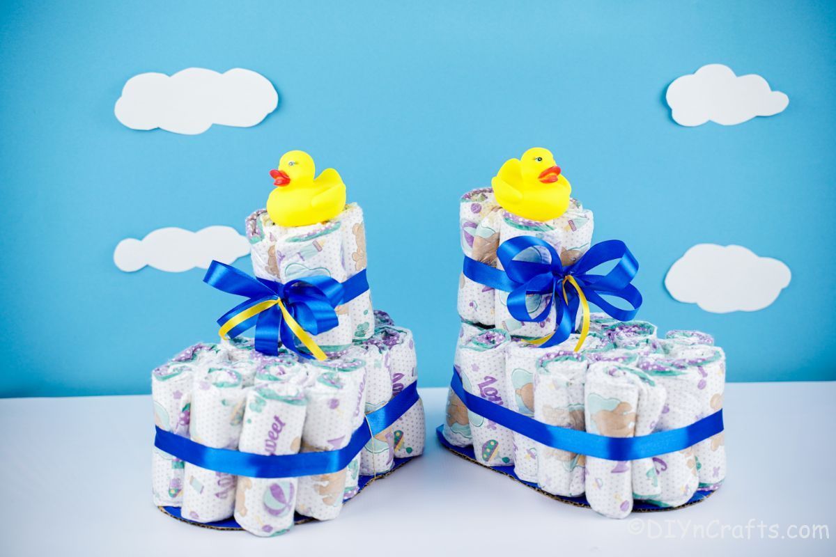 diaper cake shoes with blue ribbon and rubber ducks on top
