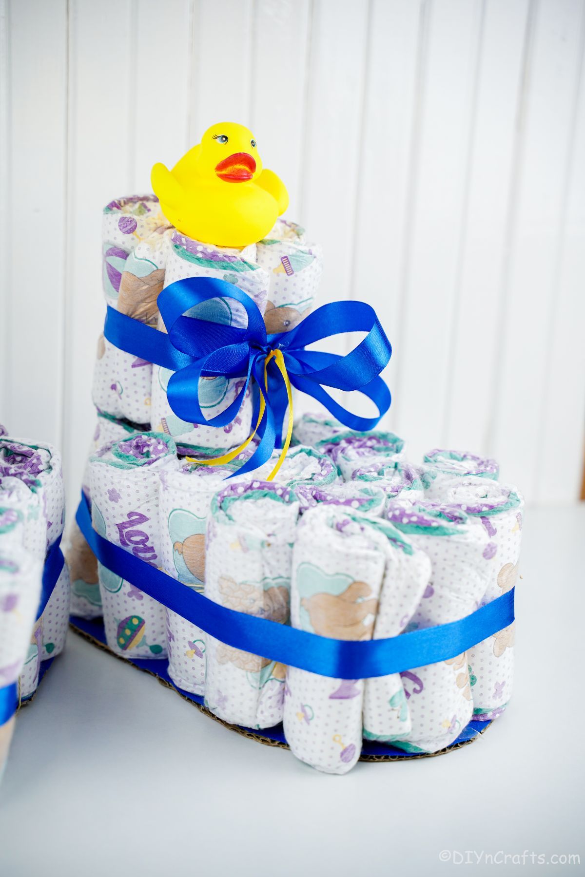 white wall behind baby bootie diaper cake