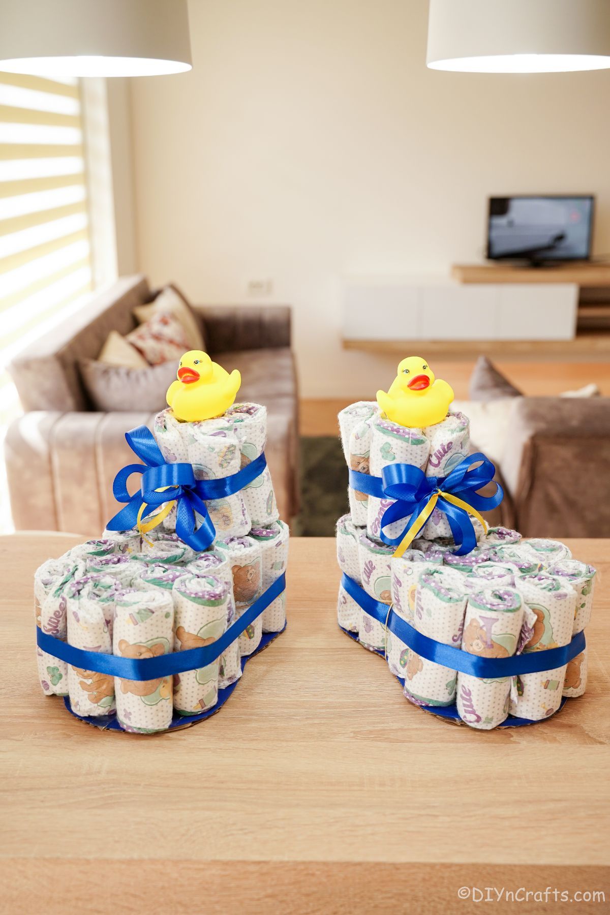 baby bootie diaper cakes with blue ribbon on table