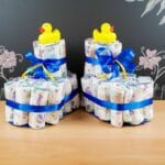 diaper cake baby botties on table in front of chalkboard