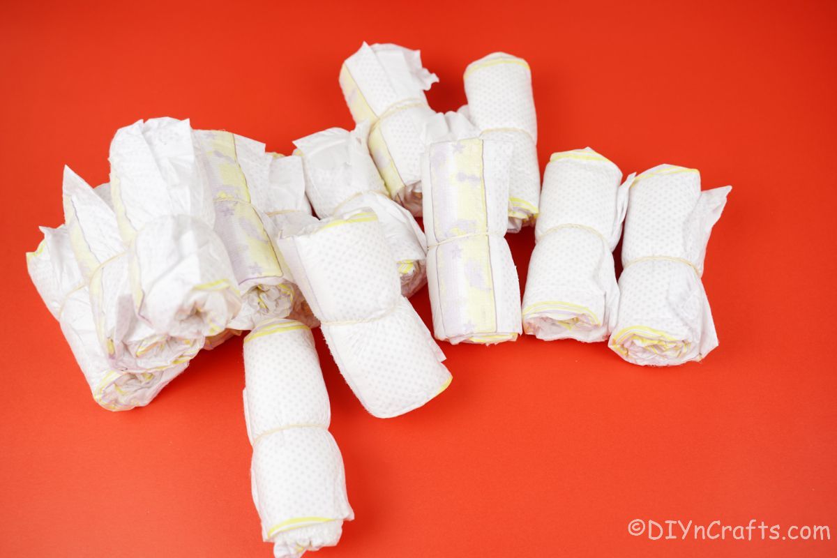 rolled diapers tacked on red table