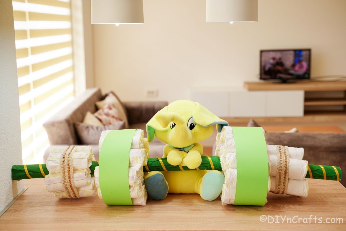 green accents on diaper cake barbell with green elephant stuffed animal