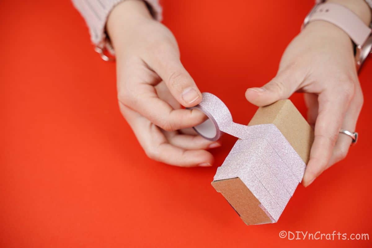 washi tape being wrapped around cardboard box