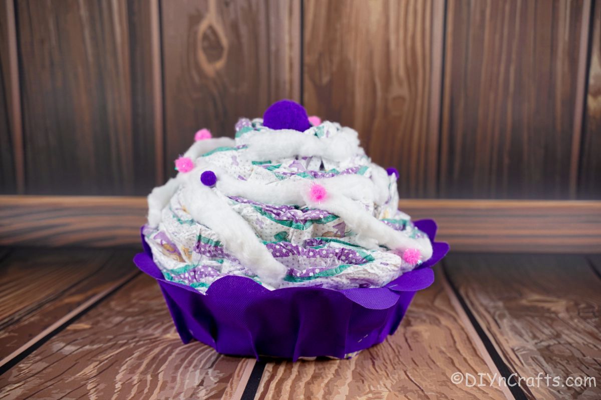 purple cupcake diaper cake on wood table